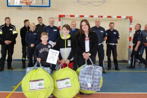 Zwycięska drużyna z Mielenka Drawskiego w tle funkcjonariusze